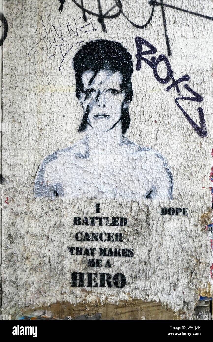 Street Art von David Bowie kommentierte Kampf der kultige Rock Star mit der schrecklichen Krankheit. Die Schablone wird durch die Abdeckung der Aladdin Sane inspiriert. Stockfoto