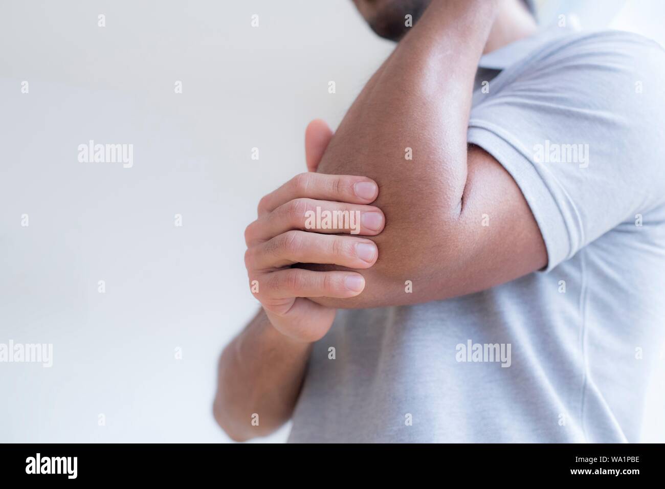 Der Mensch seine Ellenbogen berühren in den Schmerz. Stockfoto