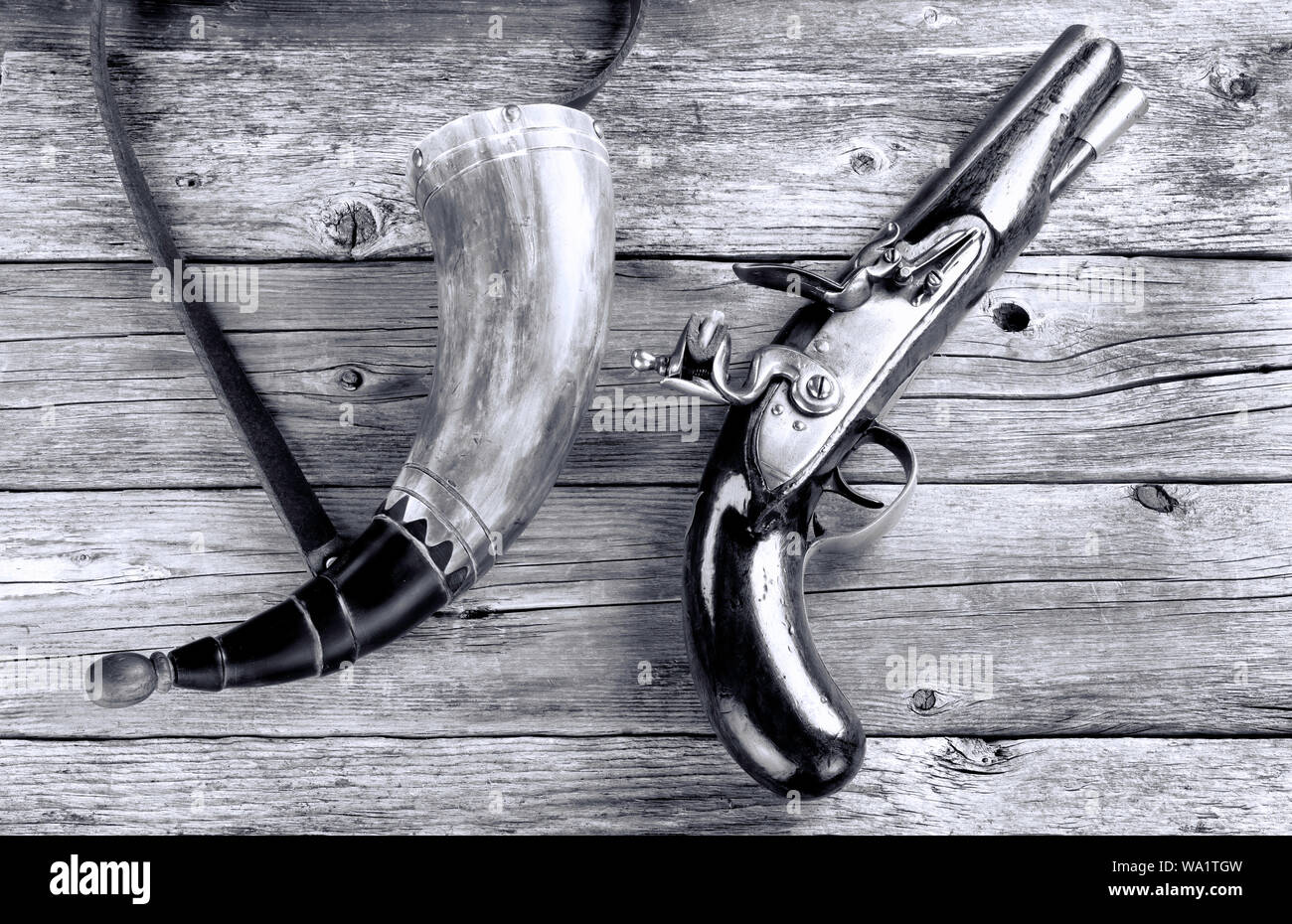 Antike Englische flintlock Pistol und Schiesspulver Horn um 1800 in Schwarz und Weiß. Stockfoto