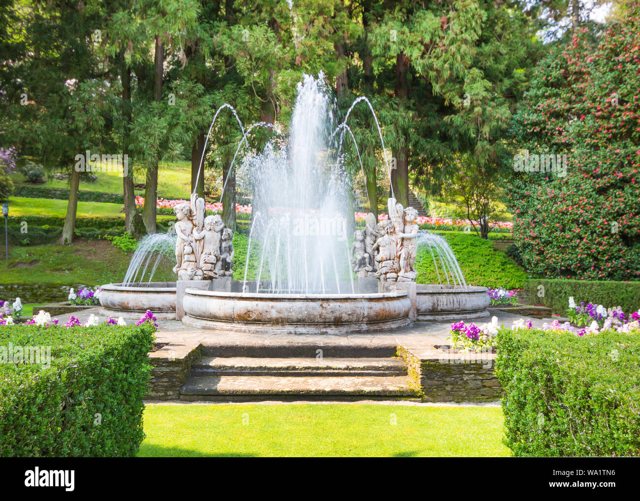 Schönen Brunnen, Wasser Brunnen mit Statue Europa Stil im Park mit Blumen im Frühling Natur Hintergrund. Stockfoto
