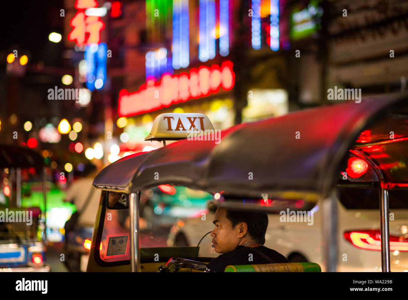 Bangkok, Thailand - Juni 5, 2019: Eine müde Tuk-tuk Fahrer in der Kabine wartet auf Kunden in der Nacht Yaowarat Street, Chinatown. Stockfoto