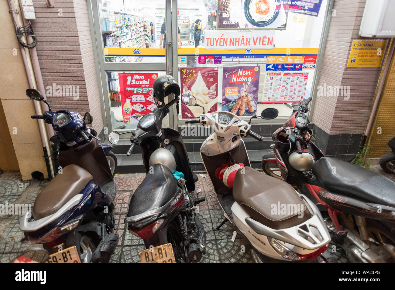 Ho Chi Minh City, Vietnam - Mai 3, 2019: ungünstig geparkte Motorräder Block die Eingangstür eines Convenience Store. Stockfoto