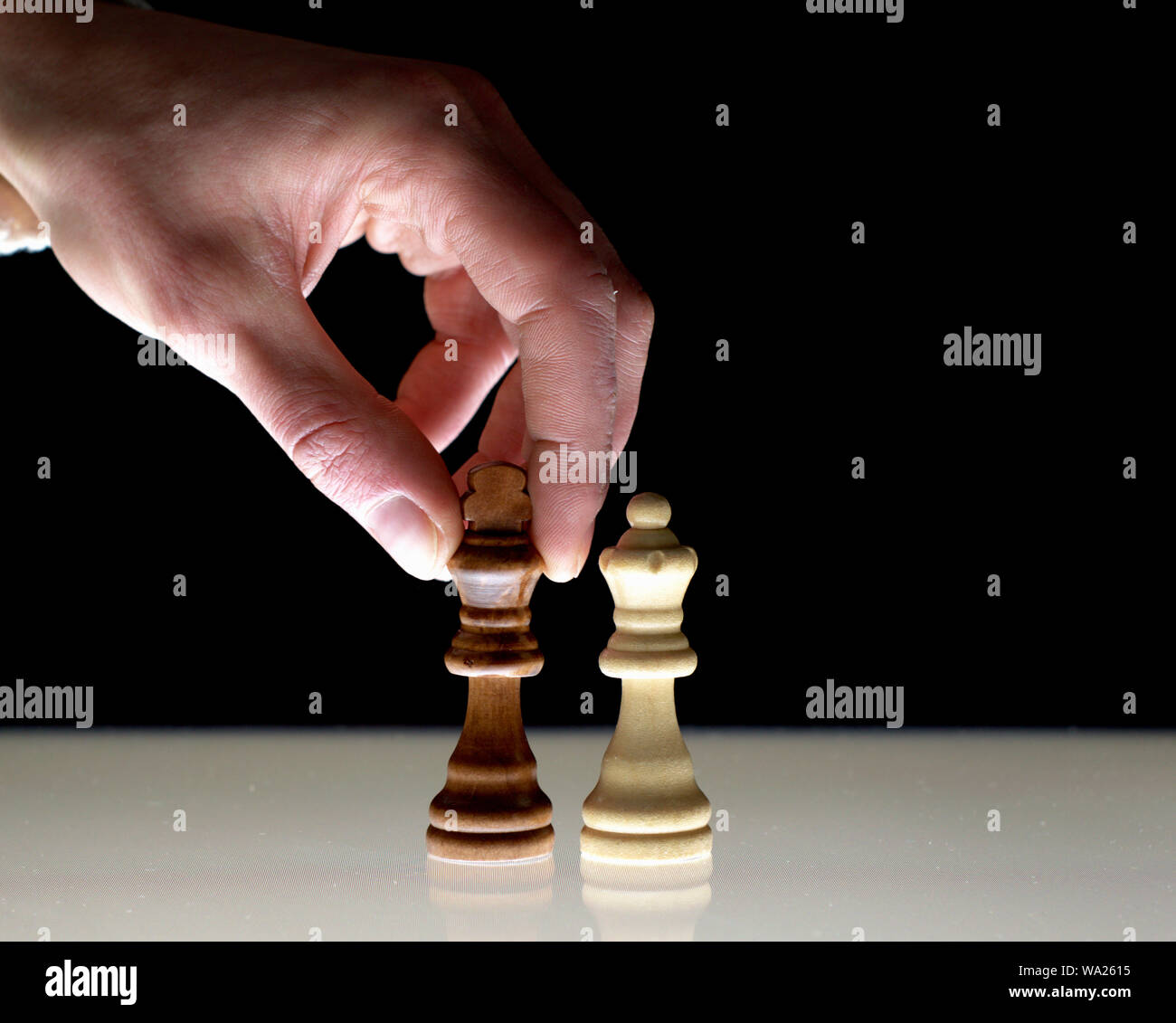 Hand verschieben einer Schwarz chess König neben dem Weißen Königin, als Konzept zur Rivalität, Konkurrenz, macht Spiele. Stockfoto