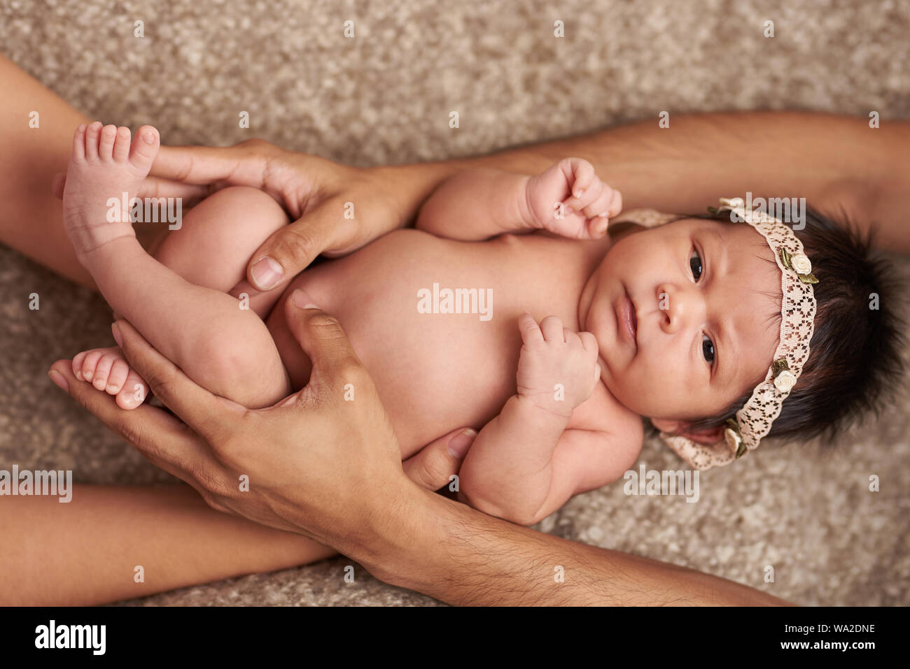 Eltern umarmt Baby liegend auf weiches Bett Stockfoto