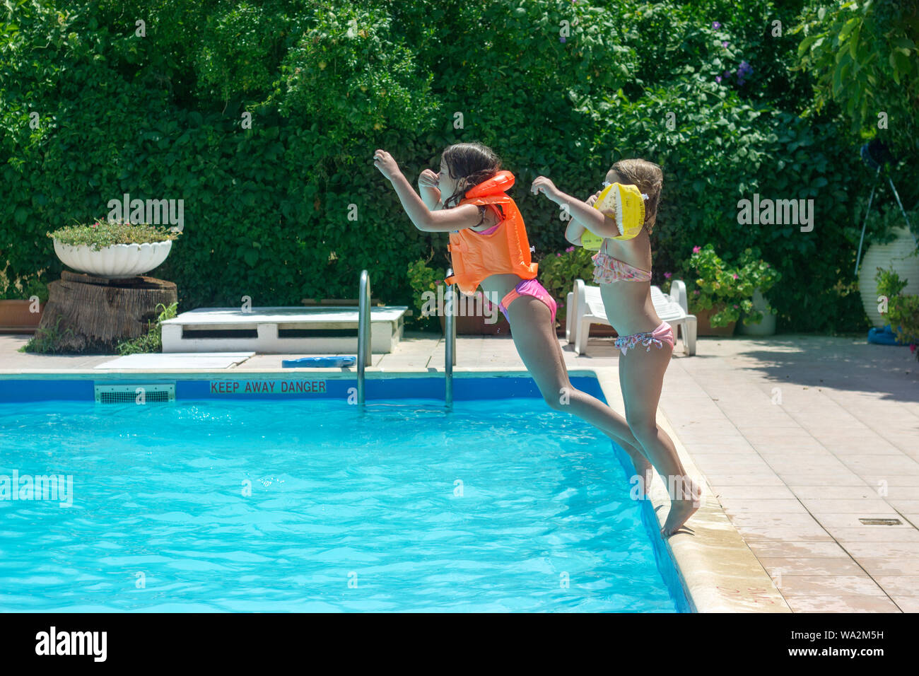 Zwei Kleine Mädchen Zusammen Springen In Den Pool Positive Emotionen Sommer Und Spaß 