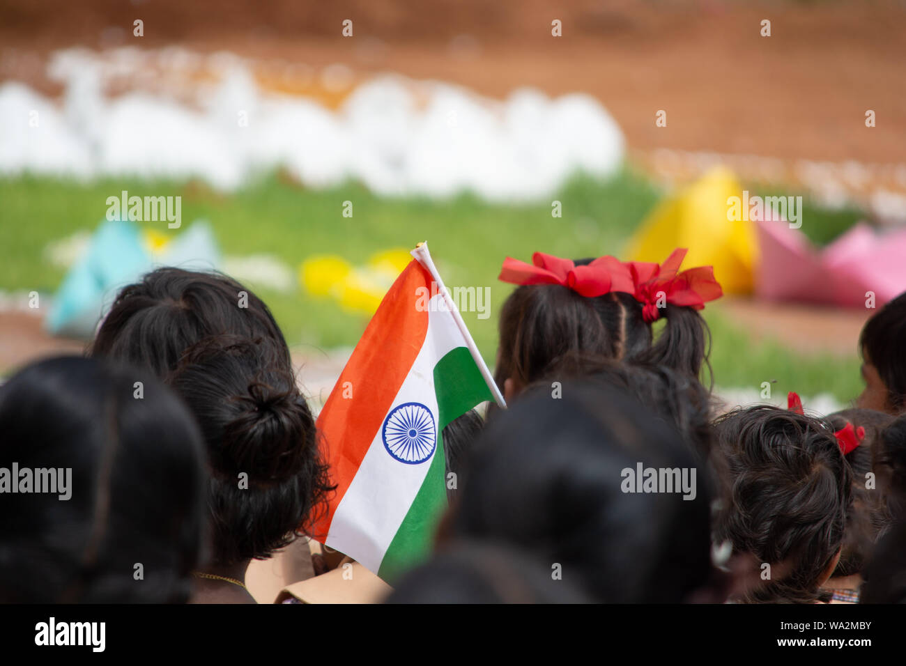 Schule Kinder saßen Boden, indem Sie die indische Flagge in der Hand während der Tag der Unabhängigkeit von Indien Stockfoto