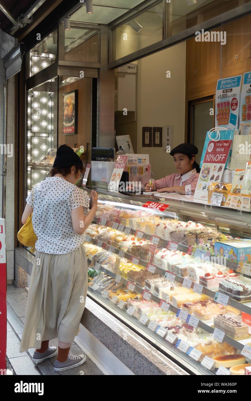 Eine japanische Frau Auswahl Kuchen in einem Geschäft, Shibuya, Tokio, Japan Stockfoto