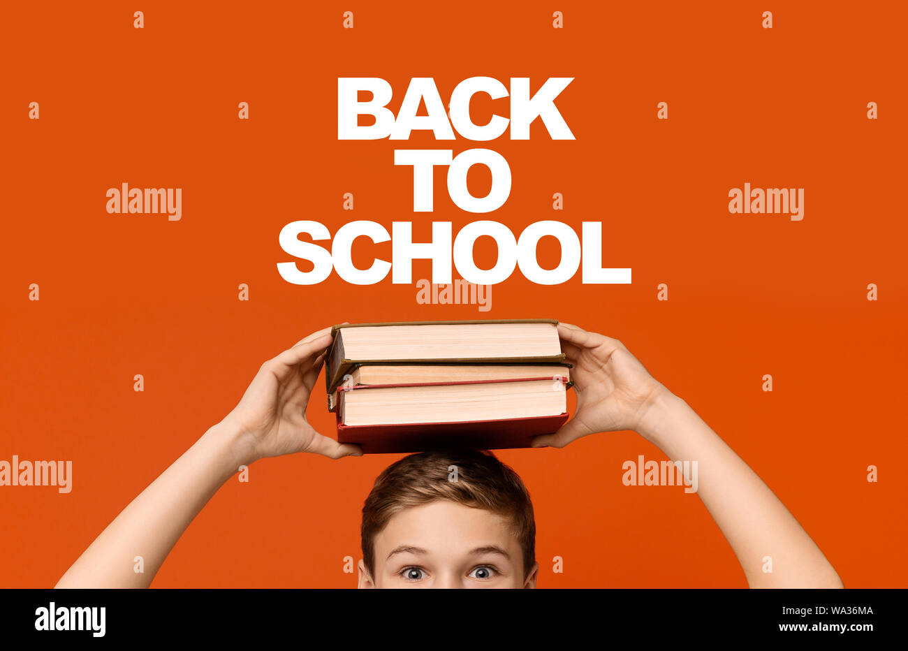 Positive Schüler Holding der Bücher auf seinem Kopf Stapel Stockfoto