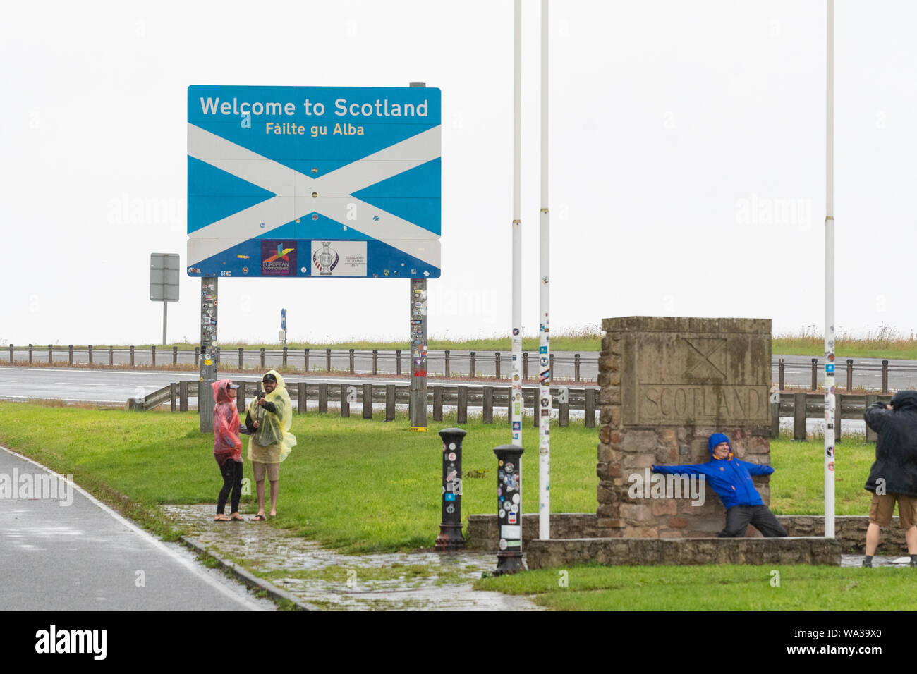 Touristen, die sich in der regen selfies auf die Übernahme der schottischen Grenze England verlassen Sie die A1 in der Nähe von Berwick, Schottland, Großbritannien Stockfoto