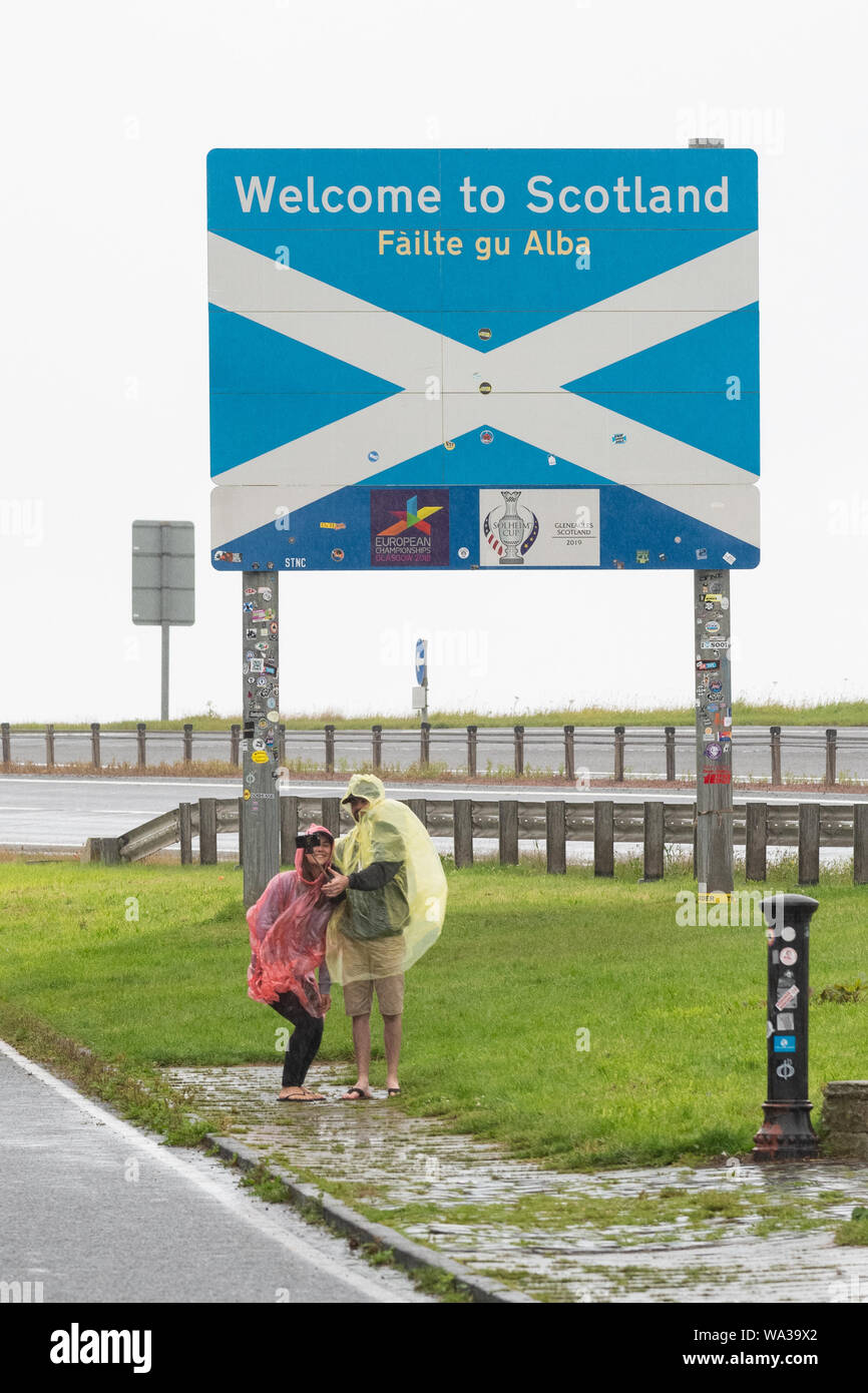 Touristen, die sich in der regen selfies auf die Übernahme der schottischen Grenze England verlassen Sie die A1 in der Nähe von Berwick, Schottland, Großbritannien Stockfoto