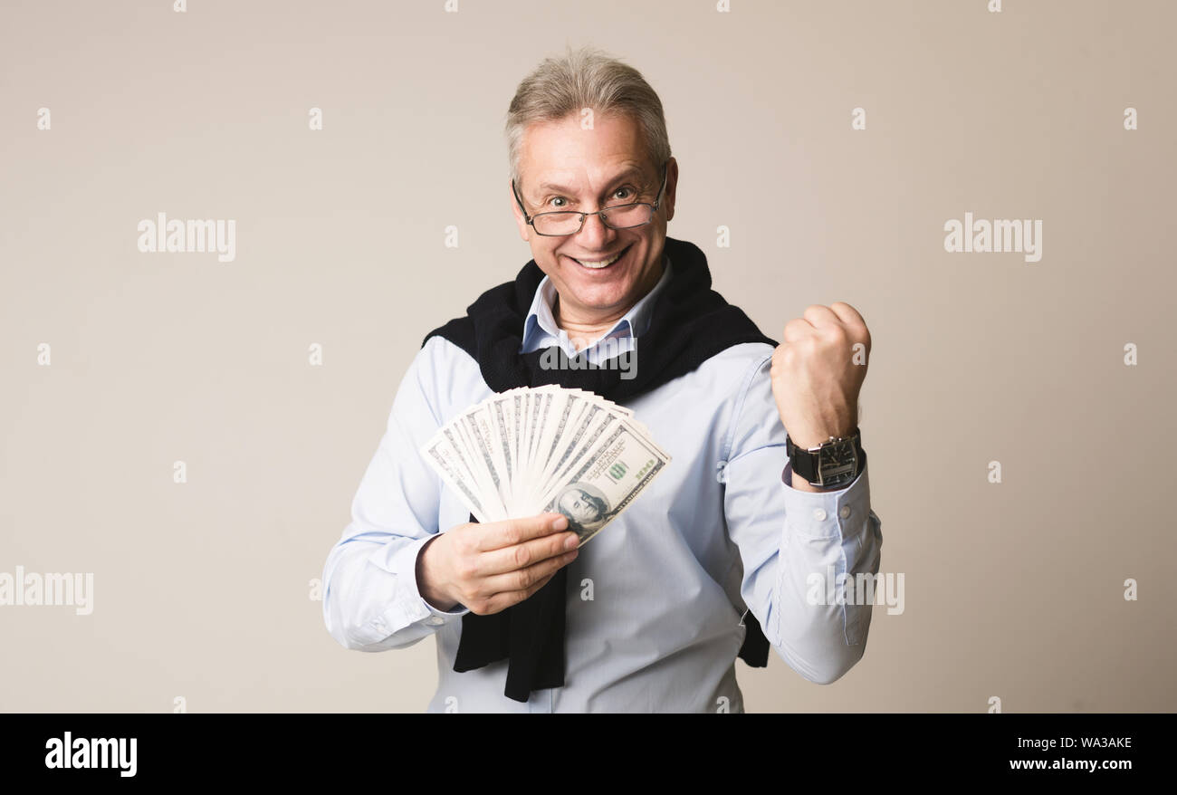 Glücklich Kaufmann mit Geld auf grauem Hintergrund Stockfoto