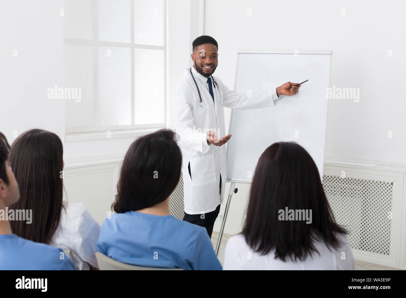 African-american Kardiologe, der Informationen zu Praktikanten bei Seminar Stockfoto