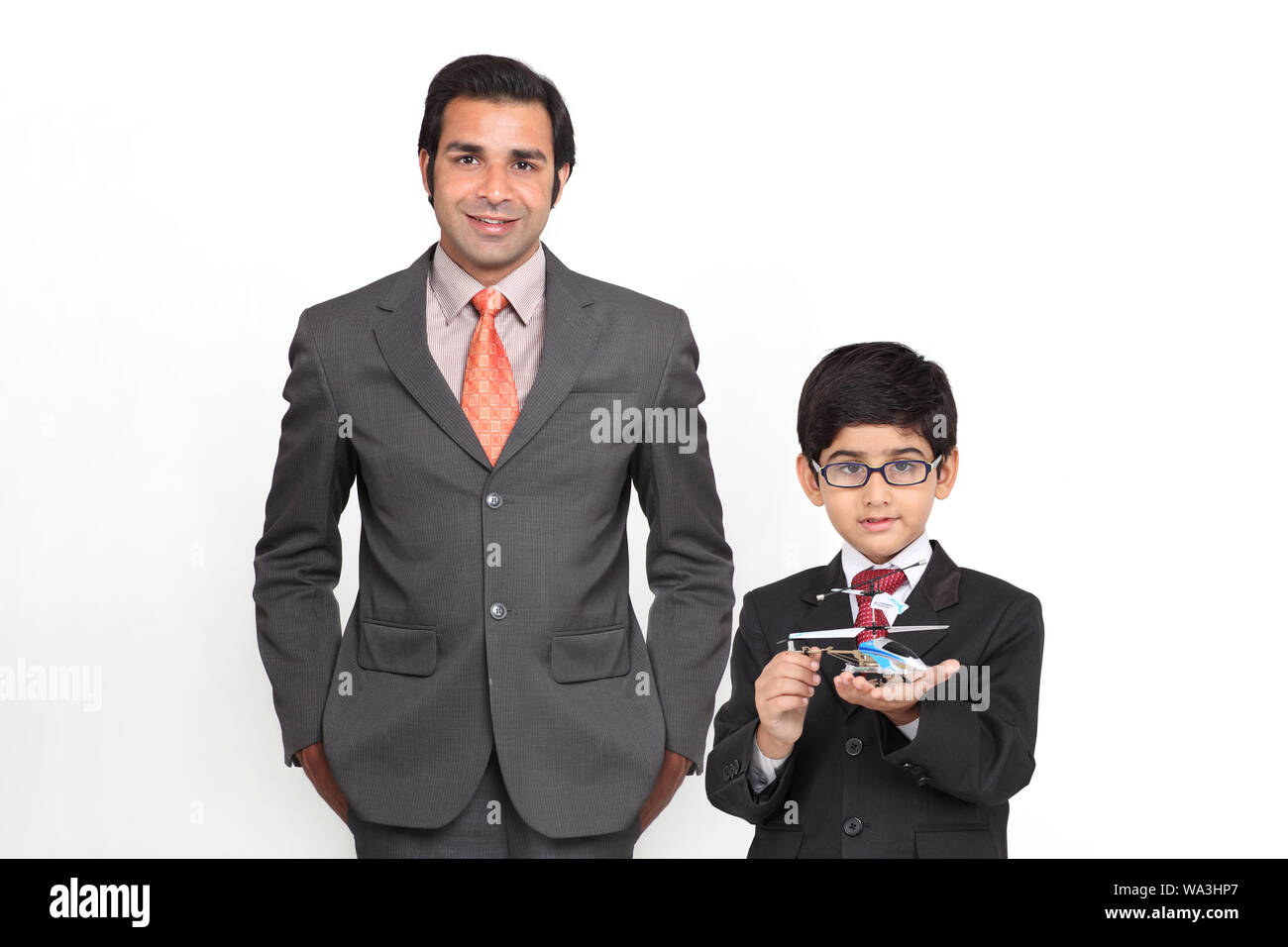 Junge imitiert als Geschäftsmann und hält ein Modellflugzeug mit seinem Vater Stockfoto