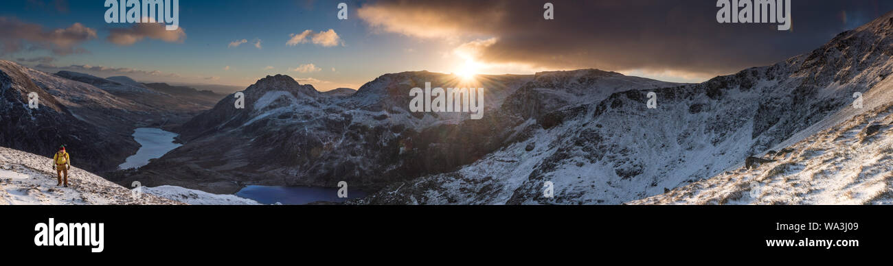 Panorama verschneiter Bergwelt bei Sonnenaufgang mit Abbildung im Vordergrund ein Stockfoto