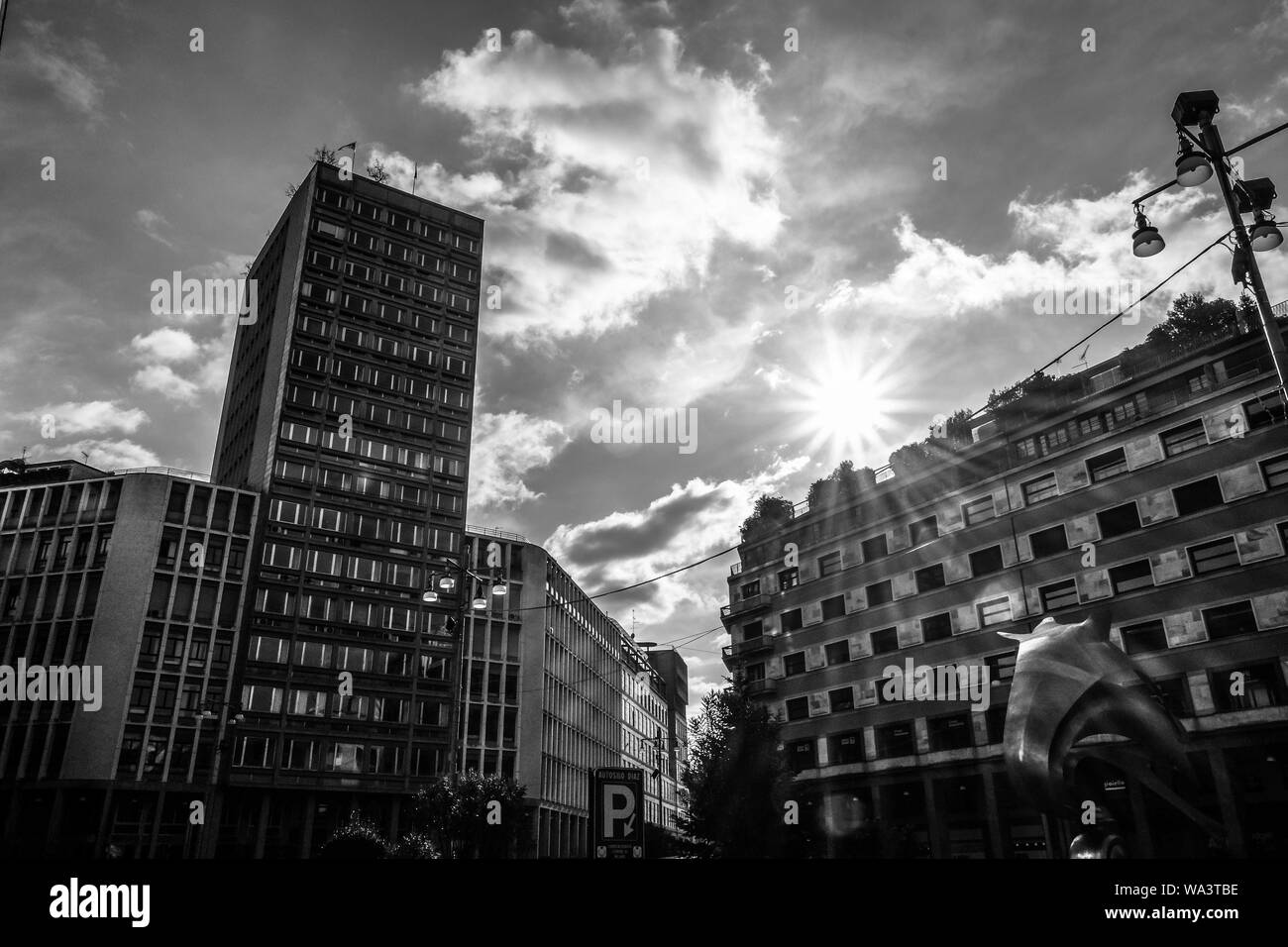 Schöne Aufnahme von Stadtgebäuden mit der Sonne scheint in Der Himmel in schwarz und weiß Stockfoto