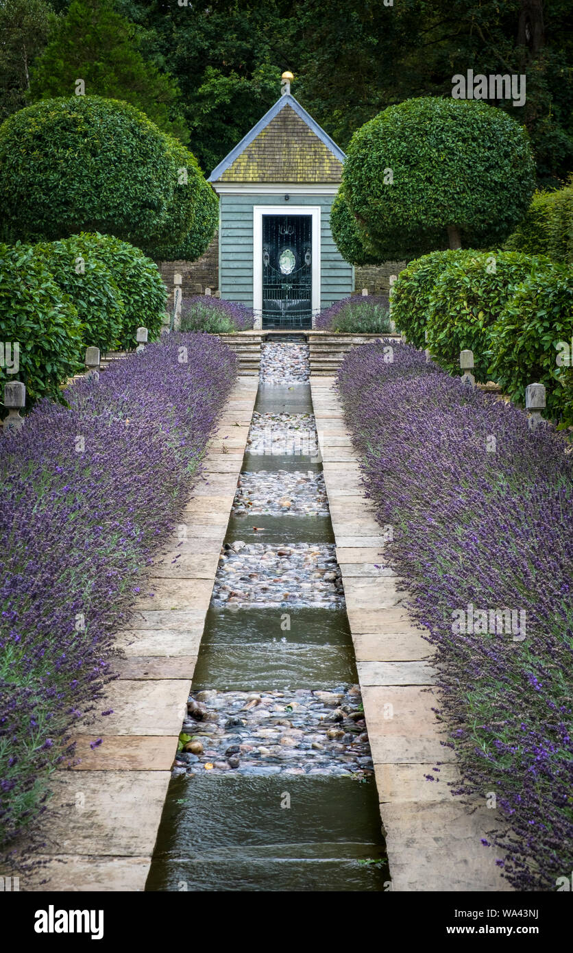 Wasserspiel mit Lavendel grenzt im Garten von Überraschungen auf dem Gelände der Burghley House Stockfoto