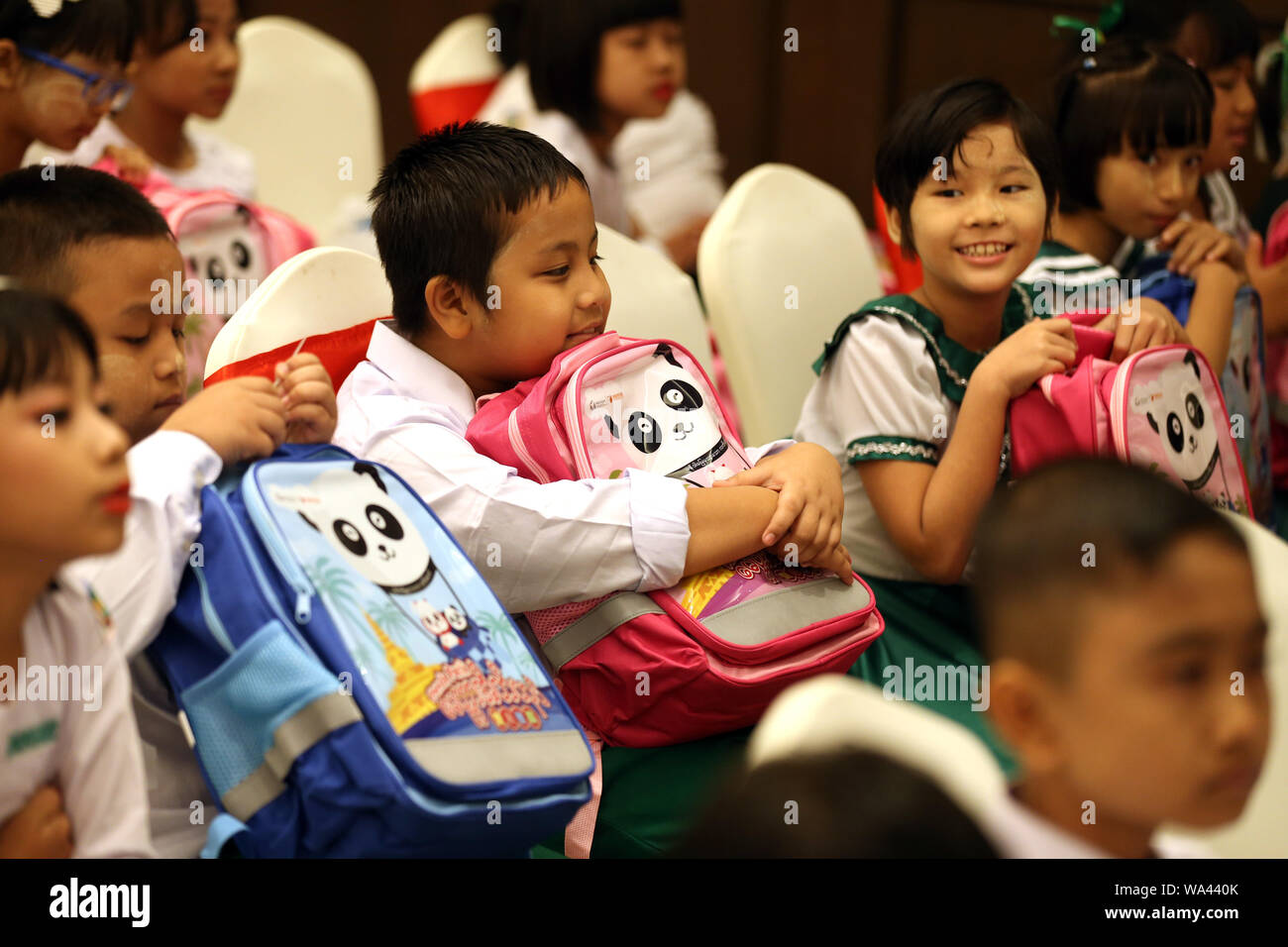 Yangon, Myanmar. 17 Aug, 2019. Studenten halten Schultaschen mit Panda Bilder während der Zeremonie für die 2019 Panda Pack Spende und der 4. Jahrestag der Chinesischen Stiftung für die Bekämpfung der Armut (CFPA) Myanmar Büro in Rangun, Myanmar, Nov. 17, 2019. China Stiftung für Armutsbekämpfung (CFPA) Myanmar Büro gespendet 100.000 Schultaschen und Schreibwarenläden in Myanmar Studenten unter Panda Pack Projekt für das akademische Jahr 2019-2020 in Yangon am Samstag. Credit: U Aung/Xinhua/Alamy leben Nachrichten Stockfoto