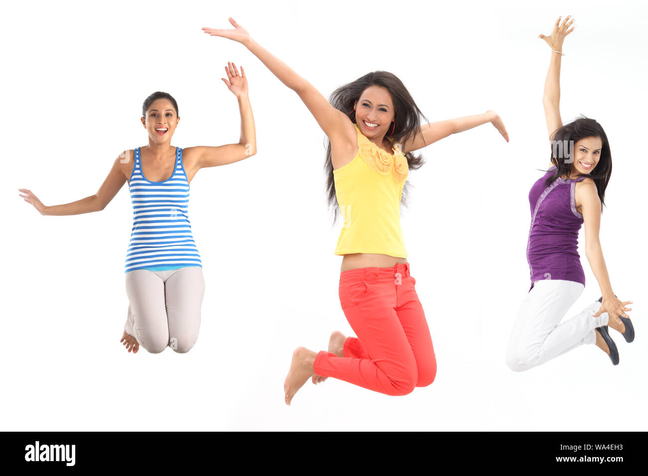 Junge Frauen springen in der Luft und lächeln Stockfoto