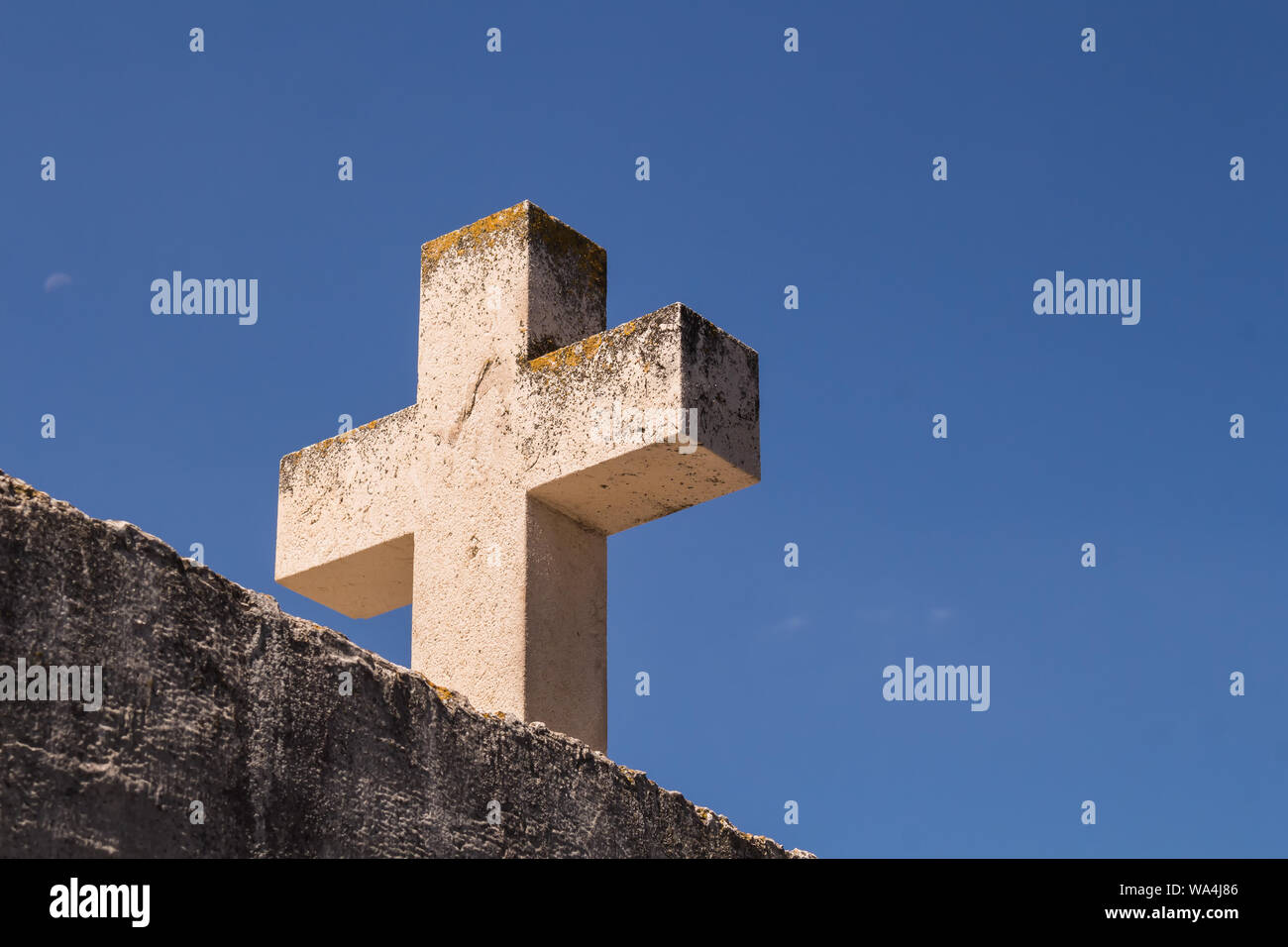Wand- und ein schweres Kreuz aus Stein. Sommer blauen Himmel im Hintergrund. Primosten, Kroatien. Stockfoto