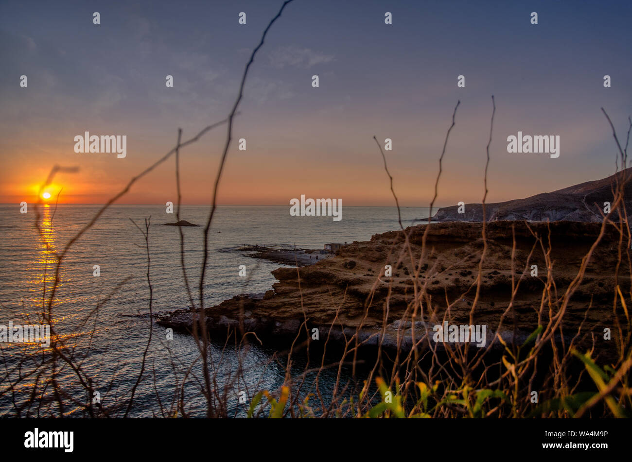 Den Sonnenuntergang unter dem schönen blauen Himmel am Strand Stockfoto