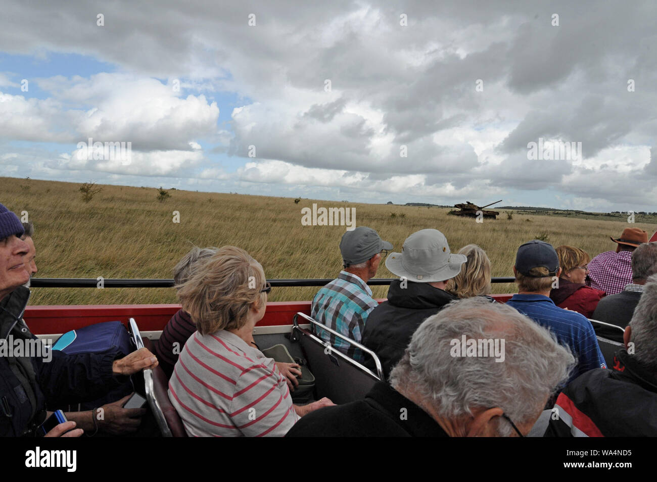 Warminster, Wiltshire, UK. 17. August 2019. Top bus Fluggäste Geöffnet auf eine Reise über Salisbury Plain eine ausgebrannte tank übergeben. Über 30 Londoner Busse, meist klassische Routemasters, sammeln in Warminster eine Busverbindung in die 'Lost village" von imber auf Salisbury Plain laufen zu lassen. Das Dorf wurde im Zweiten Weltkrieg beschlagnahmt für die Ausbildung im Jahr 1943 und ist Teil der MOD Trainingsgelände geblieben, außer bei einem Tag der offenen Tür pro Jahr. G. S. Essex/Alamy leben Nachrichten Stockfoto