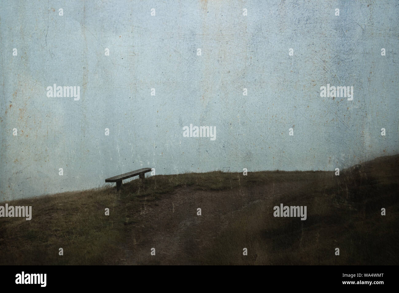 Eine Holzbank auf einem Hügel auf einer Moody, nebligen Tag, mit einem unscharfen, abstrakte, Grunge, Vintage bearbeiten. Stockfoto