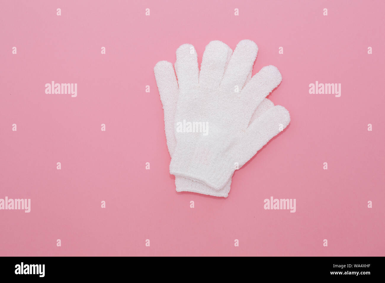 Frau Peeling massage Handschuh für Dusche auf rosa Hintergrund. Handschuhe für den Einsatz in der Dusche für Massage und Peeling. Schönheit Hintergrund mit kosmetischen Prod Stockfoto