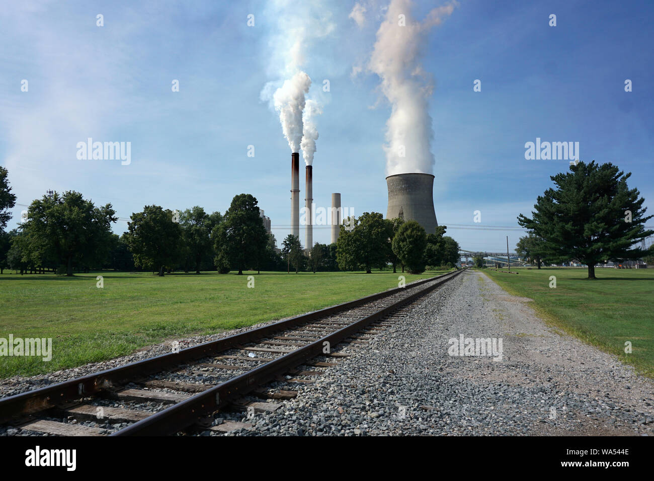 Eisenbahn Spur auf eine Kohle Kraftwerk mit Schornsteinen und einem Kühlturm Stockfoto