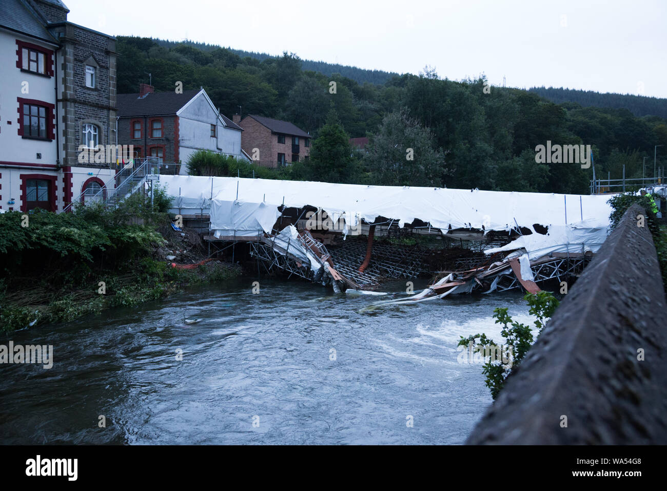 Hopkinstown, Pontypridd, South Wales, UK. 17. August 2019. Gerüst Unterstützung Castell Ifor Brücke, in der Nacht auf Freitag Hopkinstown zusammengebrochen. An diesem Abend das Gerüst unter Wasser bleibt. Die Brücke ist in Reparatur seit April, und kostet £ 450.000 für die Zukunft die schwache Brücke. Natürliche Ressourcen Wales waren sich der Zusammenbruch, und ist es nicht eine Flut Risiko versichert. Vertragspartner, die Durchführung der Reparaturarbeiten auf der Brücke waren, wird erwartet, dass das Gerüst am Montag, als der Fluss fällt zu beheben. Credit: Andrew Bartlett/Alamy Leben Nachrichten. Stockfoto
