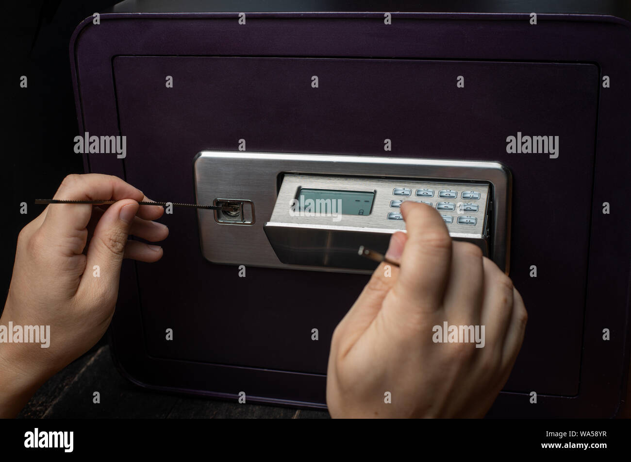 Nahaufnahme der Dieb die Hände versuchen zu brechen Home Geld sicher und Raub. Sicherheit und Home Security Konzepte. Stockfoto