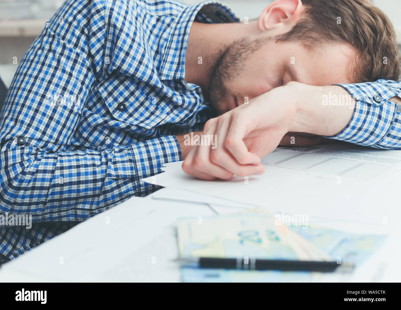 Überarbeitet und müde im Büro schlafen über bei der Arbeit am Tisch im Büro Stockfoto