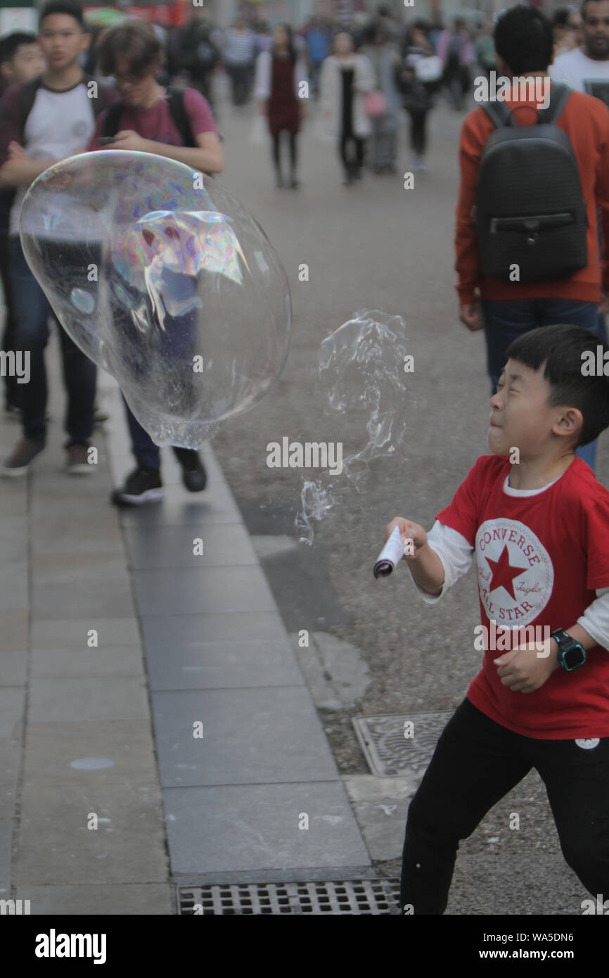 Kleine Kinder spielen mit großen Seifenblase in der Straße pic © Jack Ludlam Stockfoto