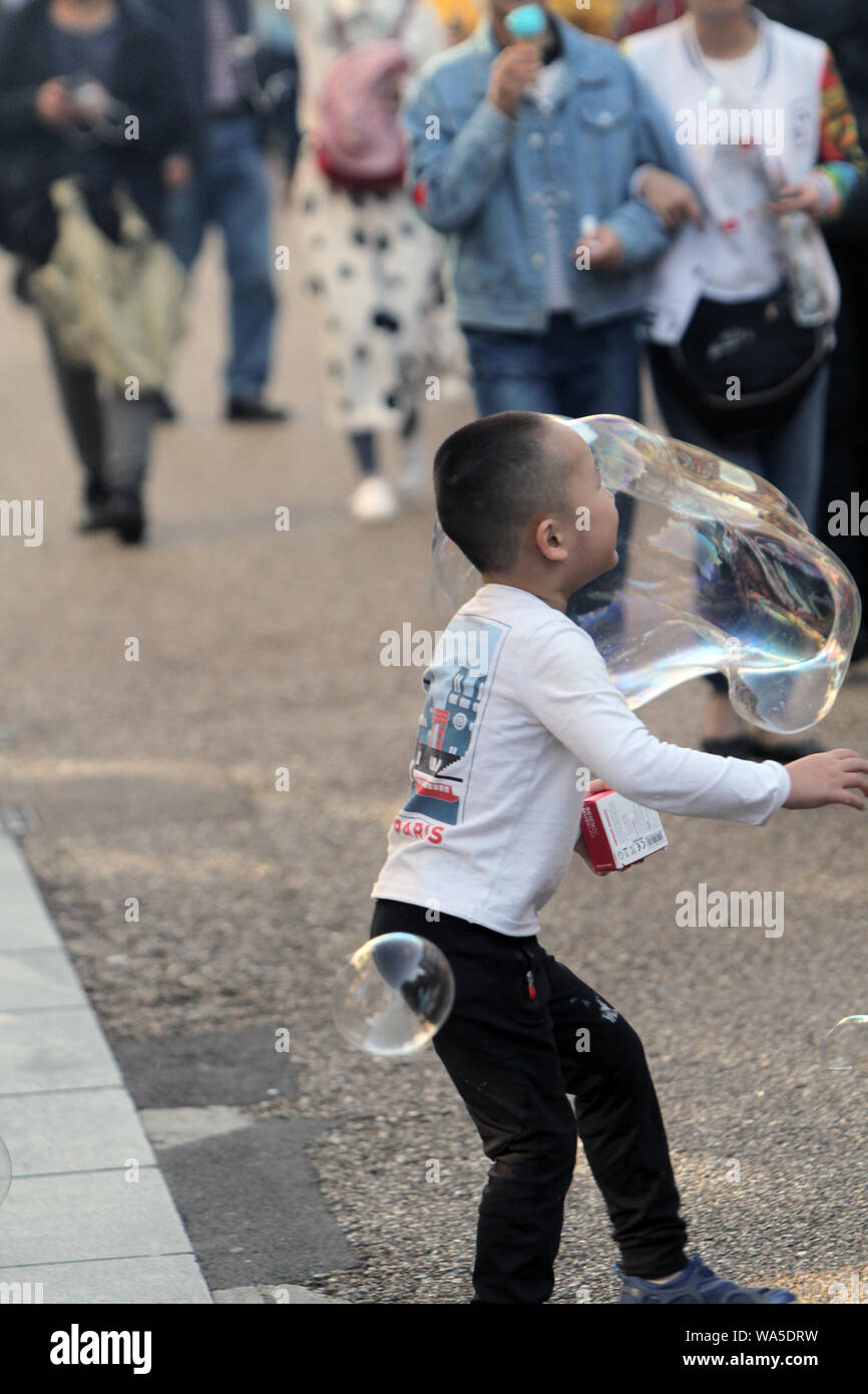 Kleine Kinder spielen mit großen Seifenblase in der Straße pic © Jack Ludlam Stockfoto