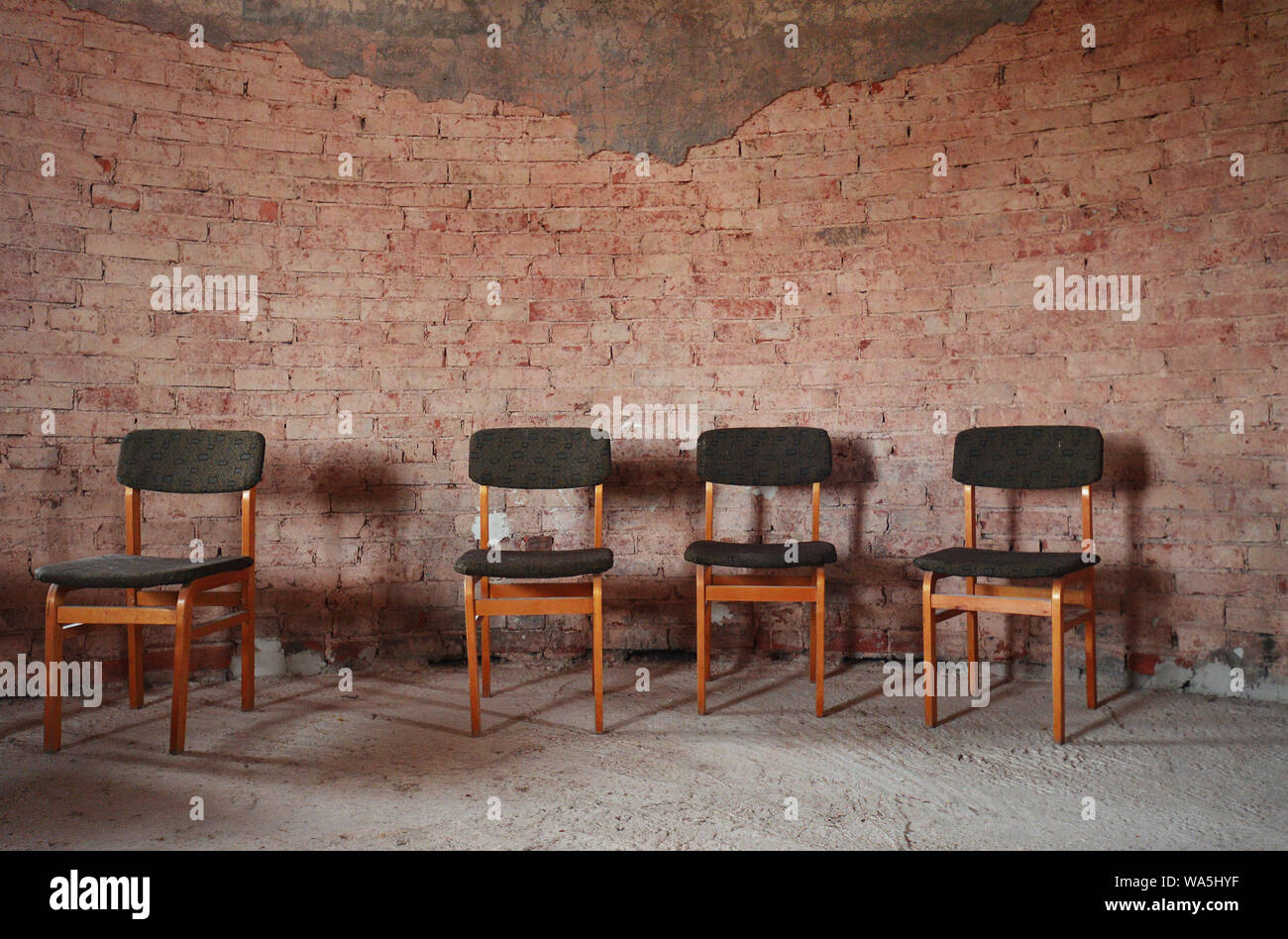 4 einsame Sessel in der Ruine's Hall Stockfoto