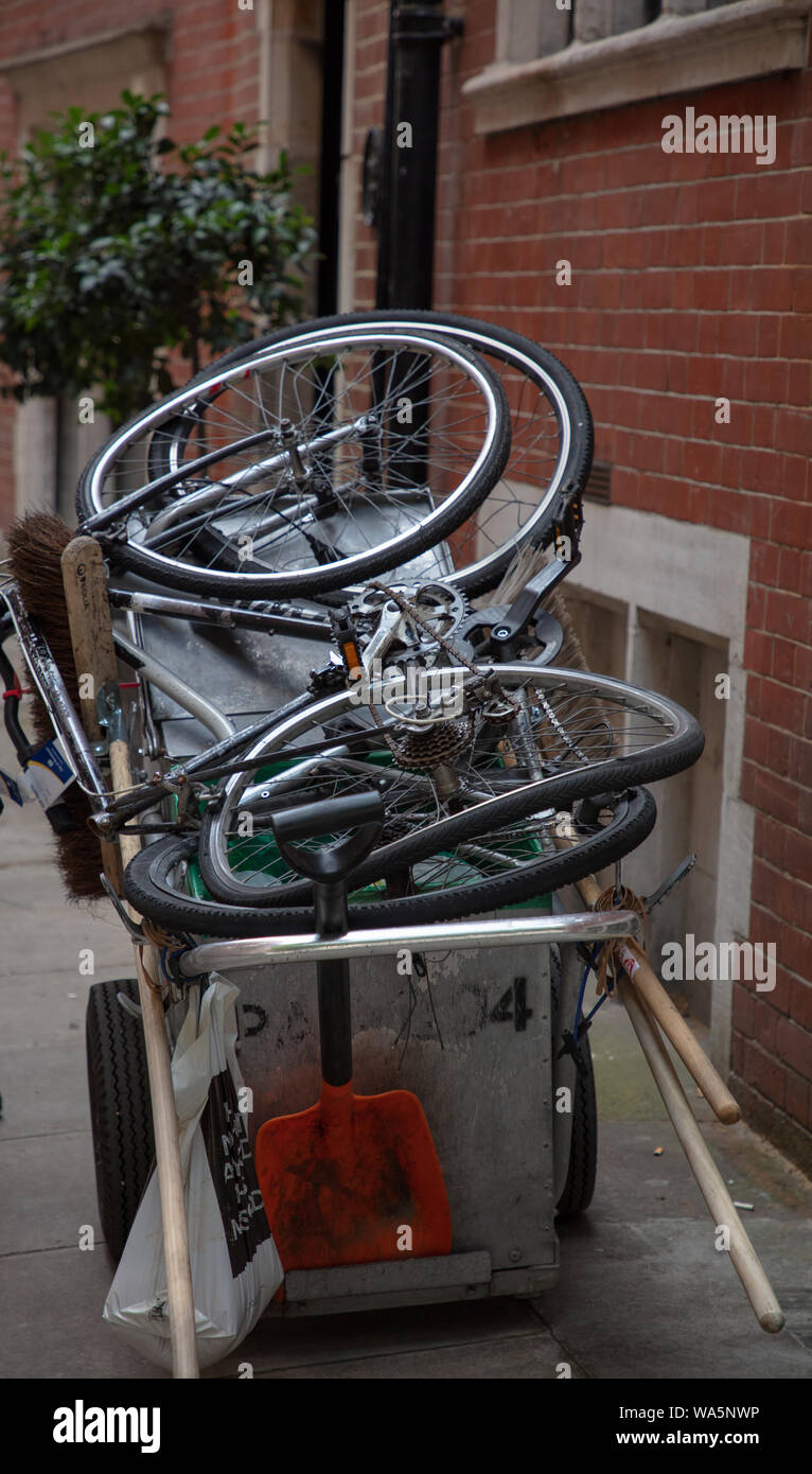 Zwei alte Fahrräder mit gedrehten Räder als Straße von Abfällen zur Verwertung in London gesammelt. Stockfoto