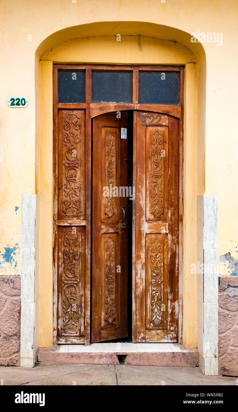 Trinidaad, Kuba 26.November 2017 - Zerschlissenen braunen Tür mit Glas oben auf der gelben wand. Schild an der Tür weist auf kubanische Volkszählung abgeschlossen Stockfoto