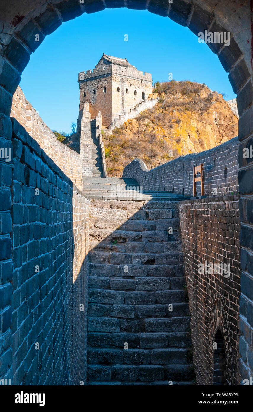 Vertikale Fotografie eines majestätischen Watch Tower mit Bogen im Vordergrund entlang der Jinshanling Chinesische Mauer bei Sonnenuntergang in der Nähe von Beijing, Asien. Stockfoto