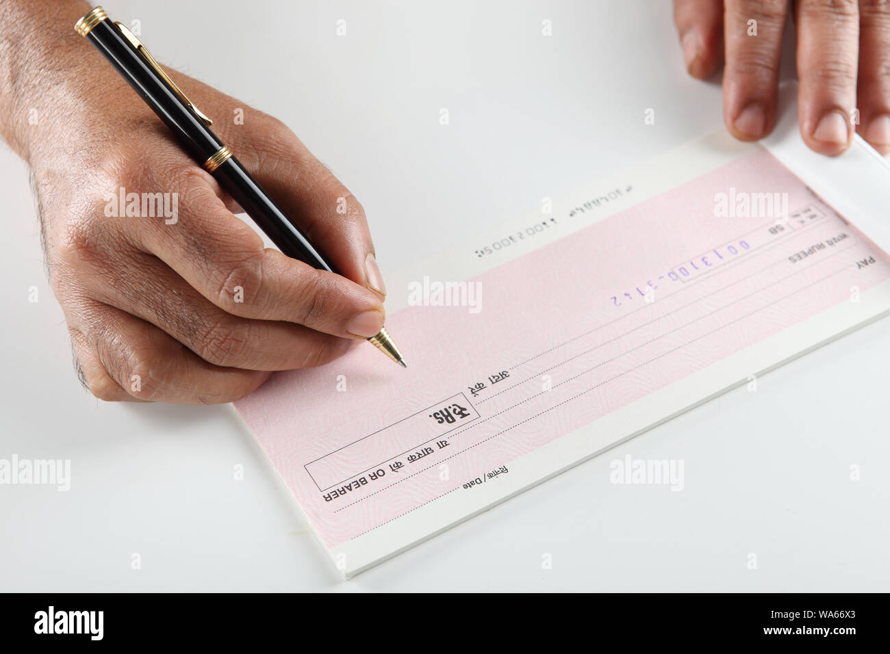Person ' s Hand Unterzeichnung ein Scheckbuch Stockfoto