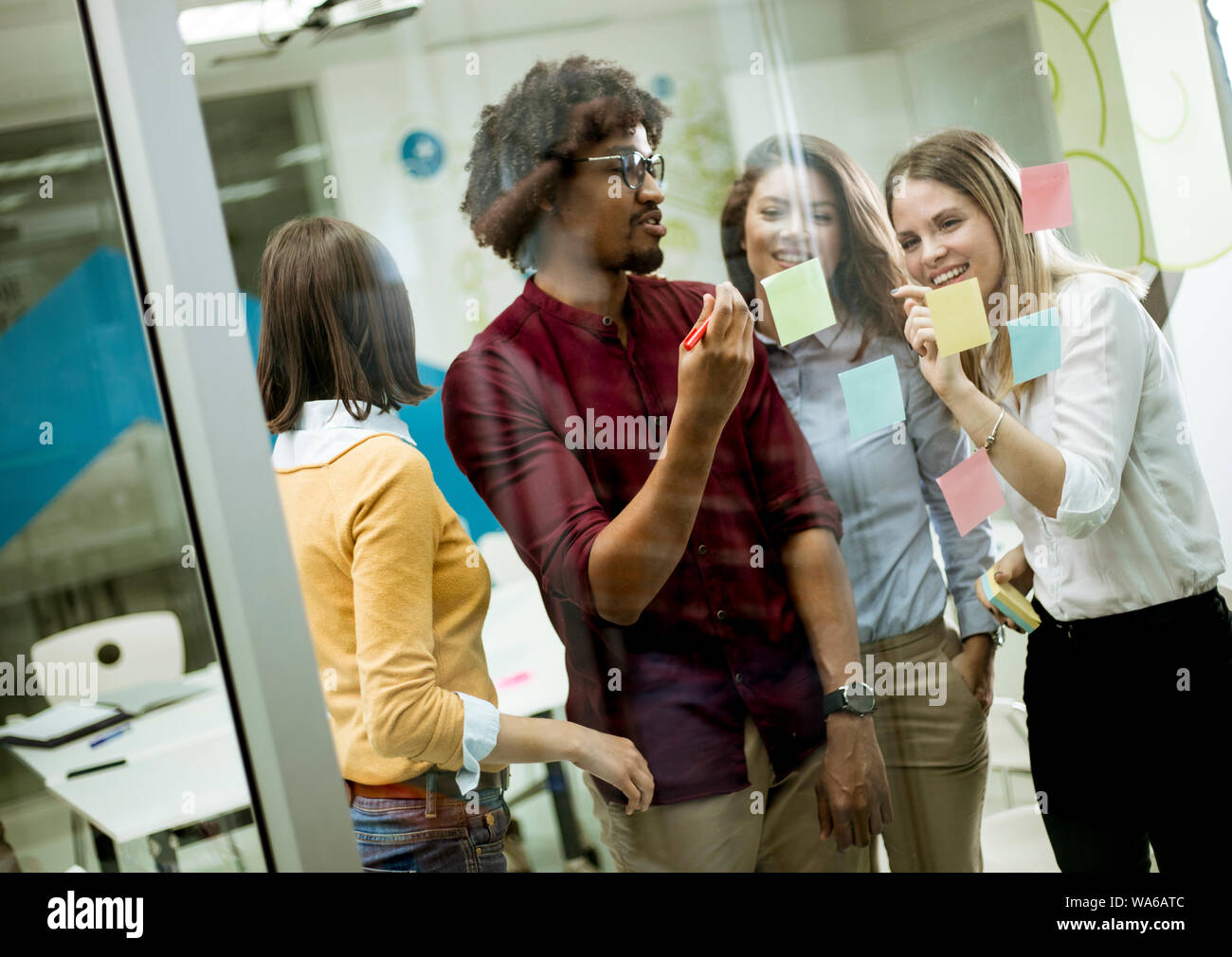 Gruppe junger Geschäftsleute diskutieren Vor der Glaswand mit Post-it Notes und Aufkleber beim Start Büro Stockfoto