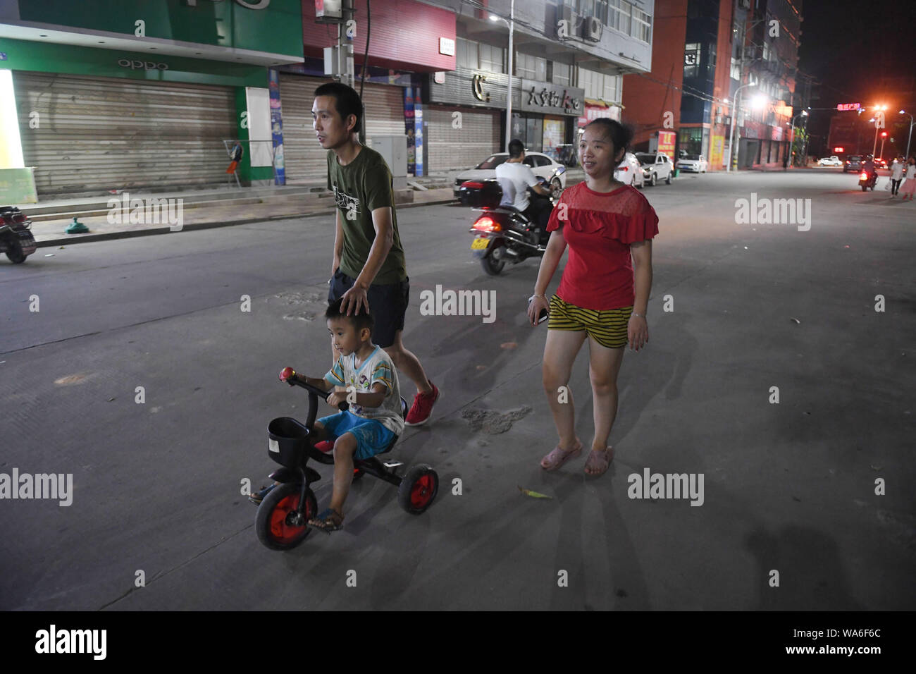 (190818) - Peking, Aug 18, 2019 (Xinhua) - Congcong und seine Eltern einen Spaziergang nach der Arbeit in Shishi im Südosten der chinesischen Provinz Fujian, Aug 5, 2019. Die Hitze wurde engulfing Shishi im Südosten der chinesischen Provinz Fujian in diesem Sommer, verlassen in der Regel zu Fuß auf den geschäftigen Straßen. Im Gegensatz dazu, Kleidung, Fabriken, die dicht in der Stadt verstreut sind, sind überfüllt mit Menschen, die mit ihrer Arbeit als Sommer überflutet worden sind, ist die Hochsaison für Kleid jedes Jahr, und auch Ihre Kinder. Der renommierte Status von shishi als große Kleidung Hersteller über dem Land ist Lar Stockfoto