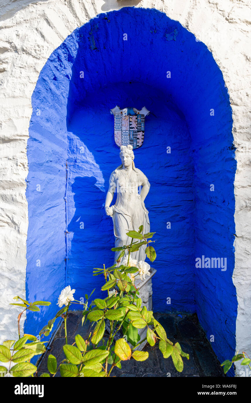 Penrhyndeudraeth, Wales, Großbritannien - 15.August 2019: das antike Griechenland inspiriert Statue auf einem leuchtend kobaltblauen Hintergrund in Portmeirion Stockfoto