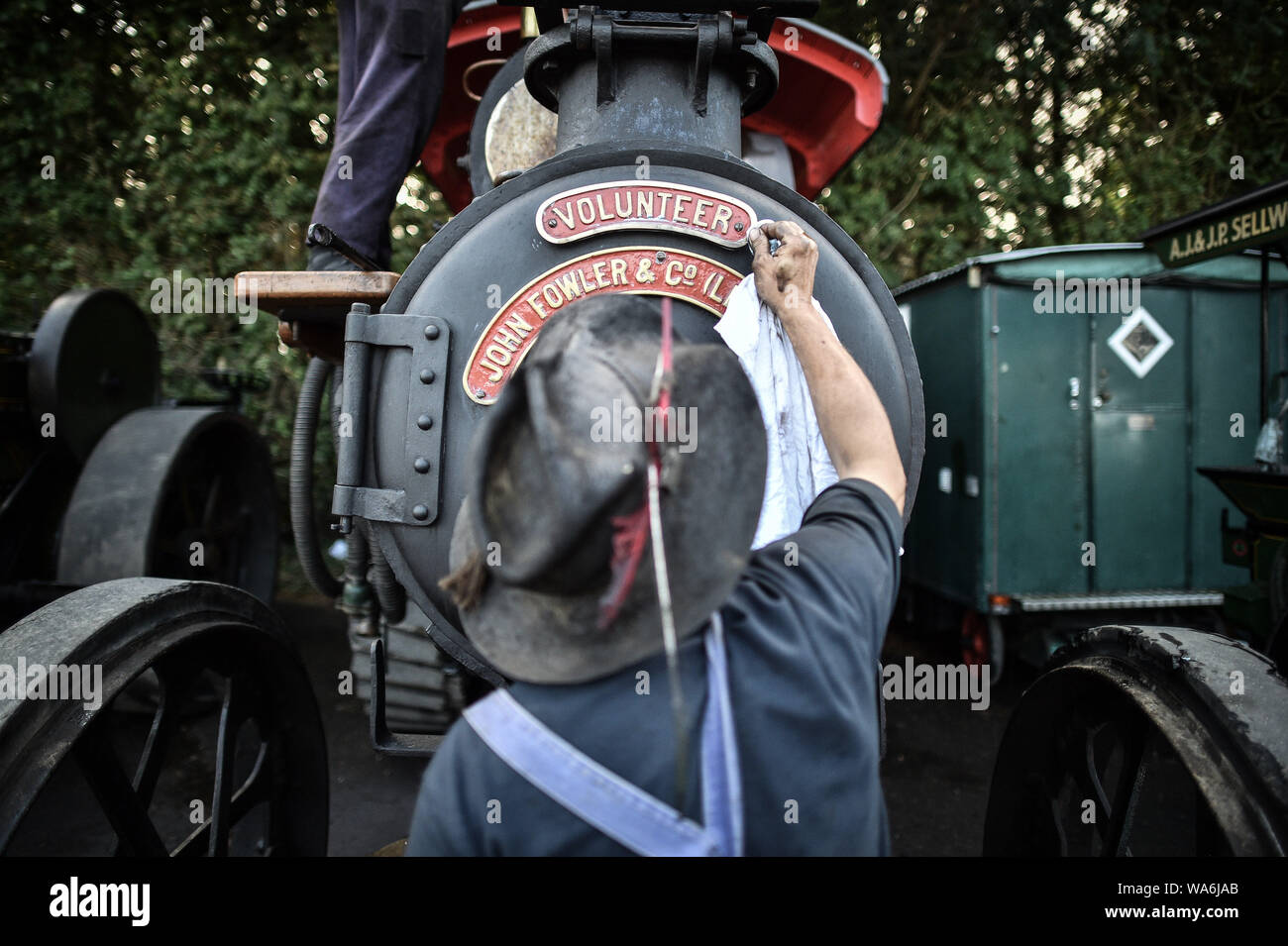 Ein Mann poliert Messing Detail auf einer Lokomobile bei drusilla's Inn, in der Nähe von Horton, Dorset, als Dutzende von Dampf angetriebene Fahrzeuge bereiten den Weg in die Great Dorset Steam Fair, wo sie von Tausenden Fans feiern Dampfkraft ab 22. August Wochenende verbunden wird. Stockfoto