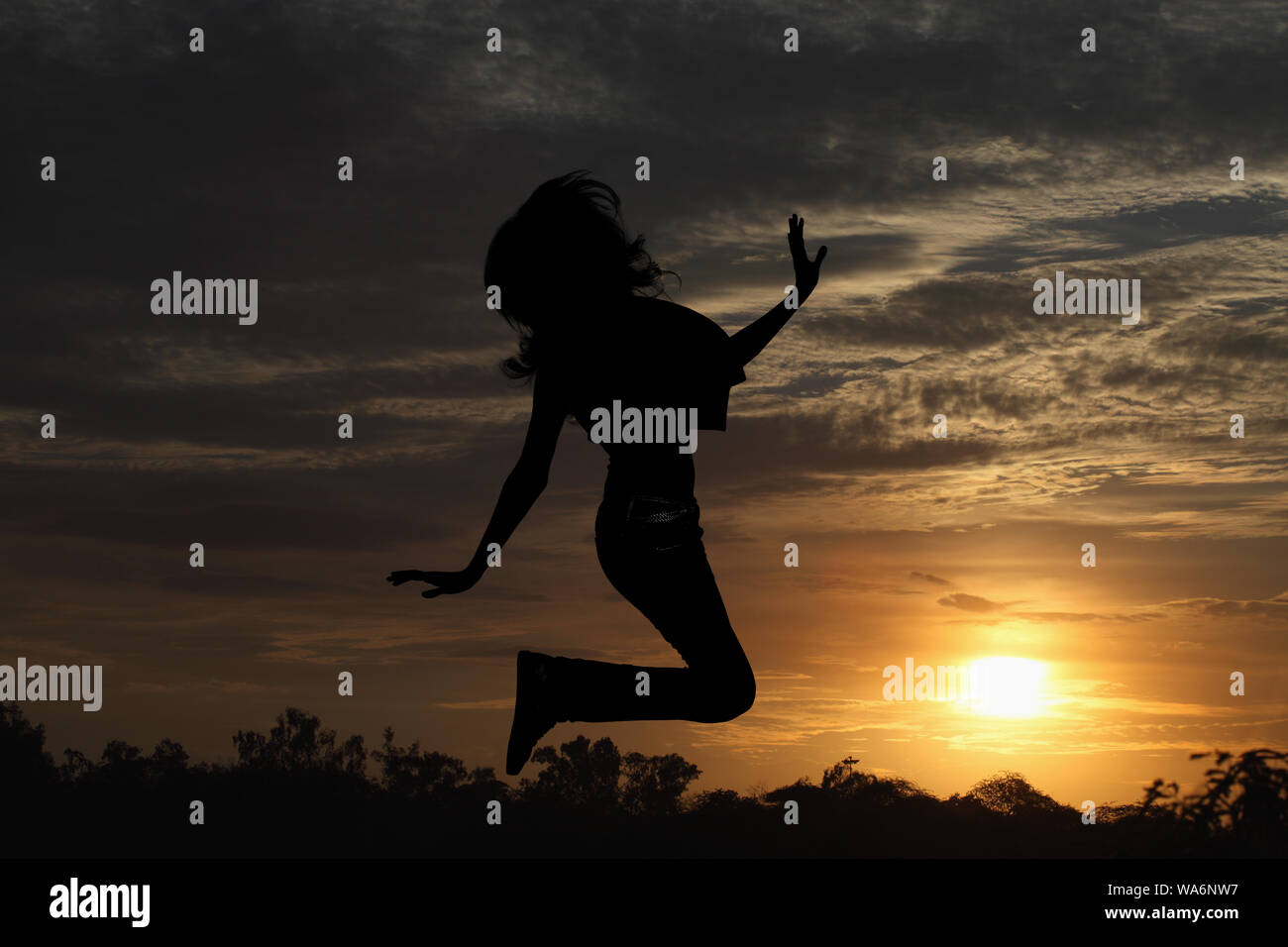 Silhouette einer Frau, die in der Luft springt Stockfoto