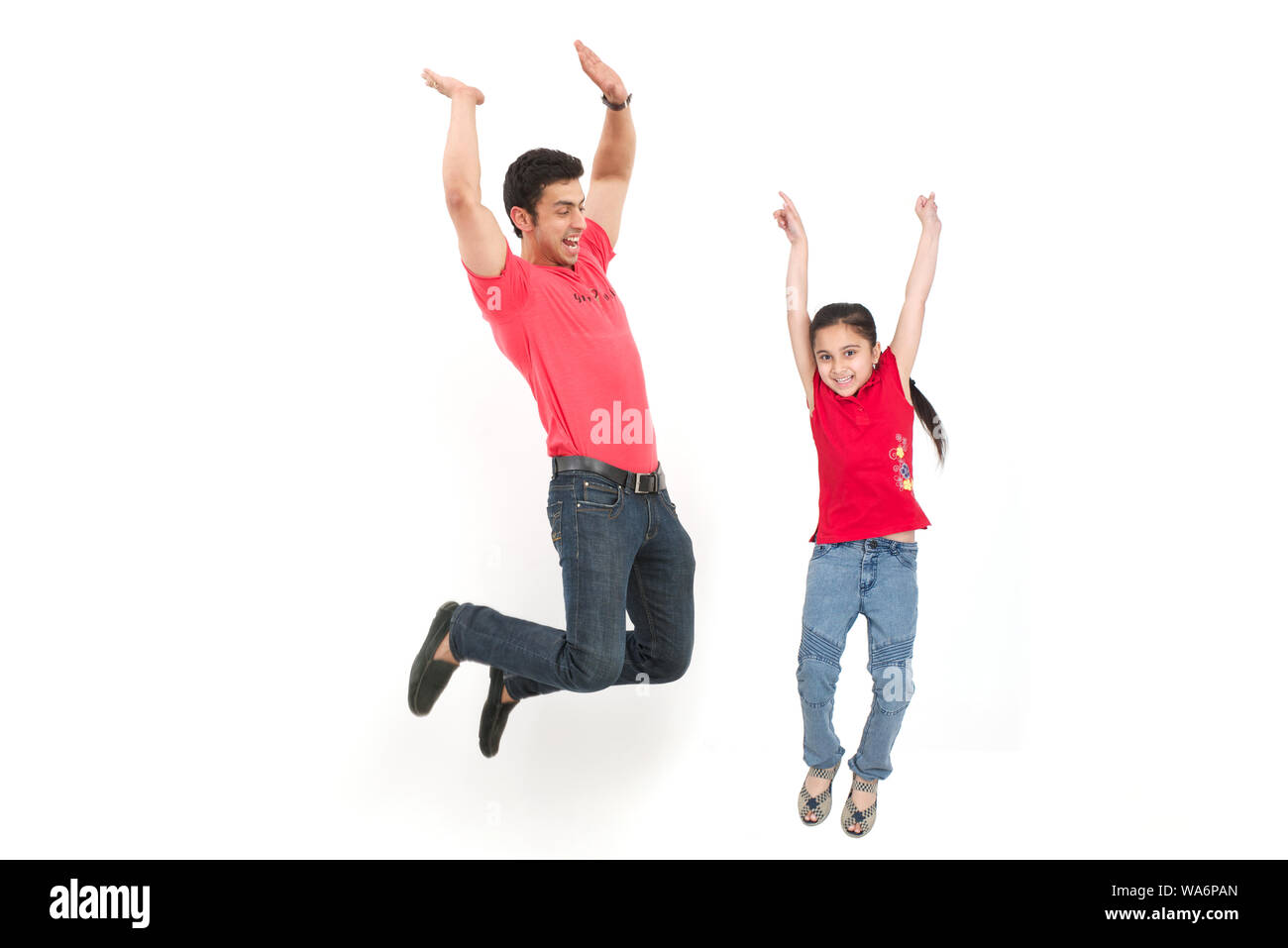 Mann mit seiner Tochter, die in der Luft springt und lächelt Stockfoto