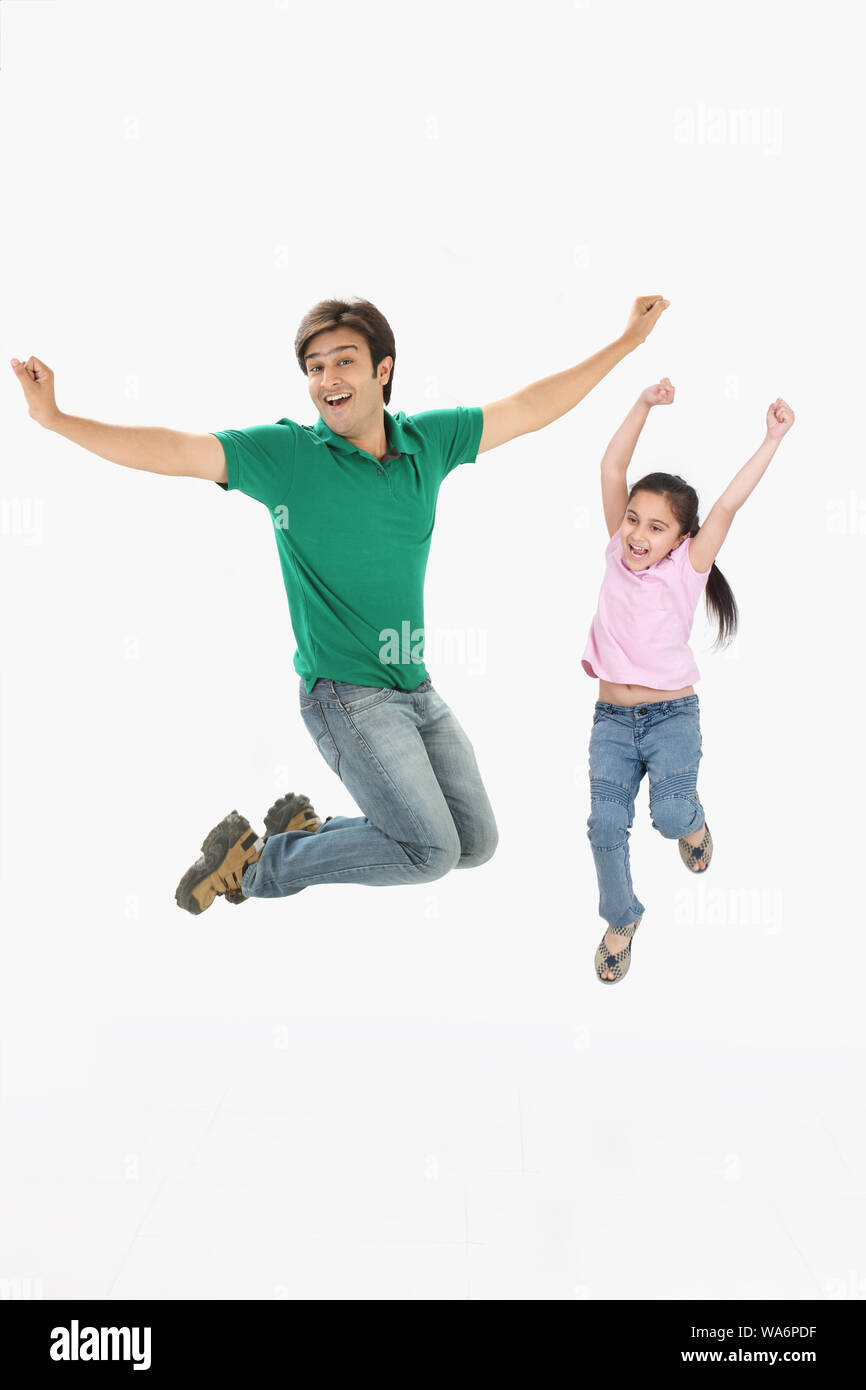 Mann mit seiner Tochter, die in der Luft springt Stockfoto