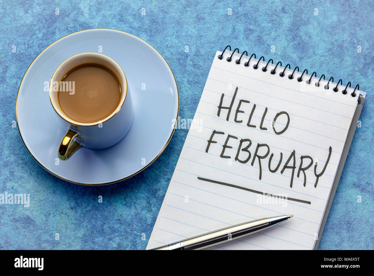 Hallo Februrar, - Handschrift in einem Notebook mit einer Tasse Kaffee Stockfoto