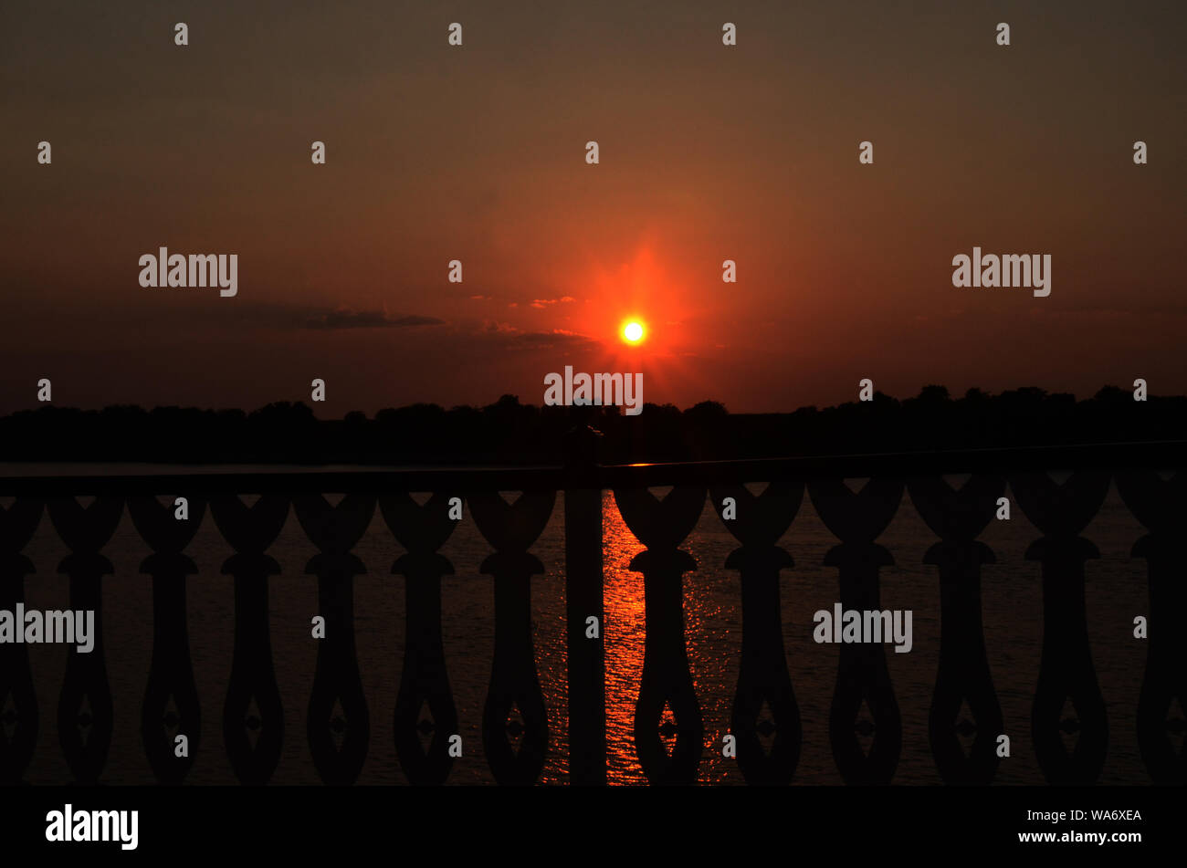 DER VORHANG RUFT: Ein dramatischer und wunderschöner Sonnenuntergang schmilzt vor der Kulisse des Savannah River in Georgia. Stockfoto