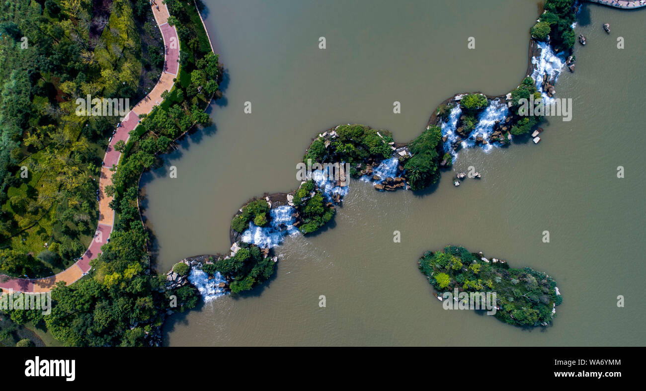 (190818) - Kunming, Aug 18, 2019 (Xinhua) - luftaufnahme am 12.08.17, 2019 zeigt eine Ansicht der Kunming Wasserfall Park in Kunming, Provinz Yunnan im Südwesten Chinas. Als Hauptstadt der Provinz Yunnan, Kunming ist nicht nur eine Verkehrs- und Informationsdrehscheibe, sondern auch ein regionales Zentrum für politische, wirtschaftliche, kulturelle, pädagogische, wissenschaftliche Forschung und soziale Dienste. Milden Klimas der Stadt ermöglichen, frischen Blumen und üppigem Grün das ganze Jahr über wachsen, machen ihn zu einem angenehmen Ort zu besuchen und im Leben. (Xinhua / Jiang Wenyao) Stockfoto