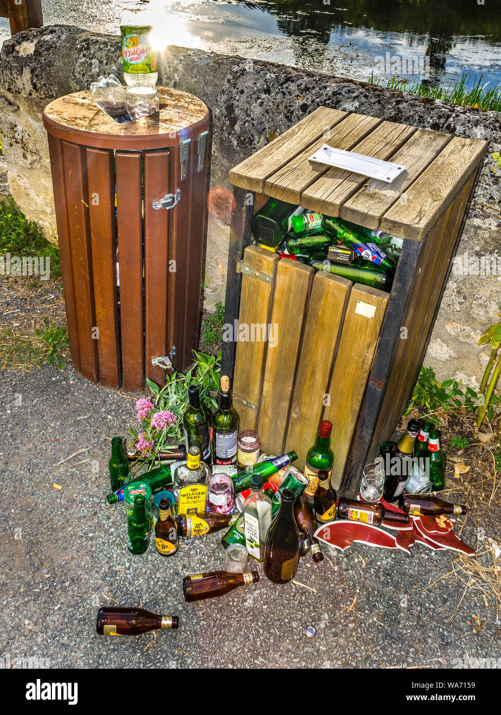 Riverside Mülleimer überfüllt mit Bier und Wein Flaschen - Vienne, Frankreich. Stockfoto