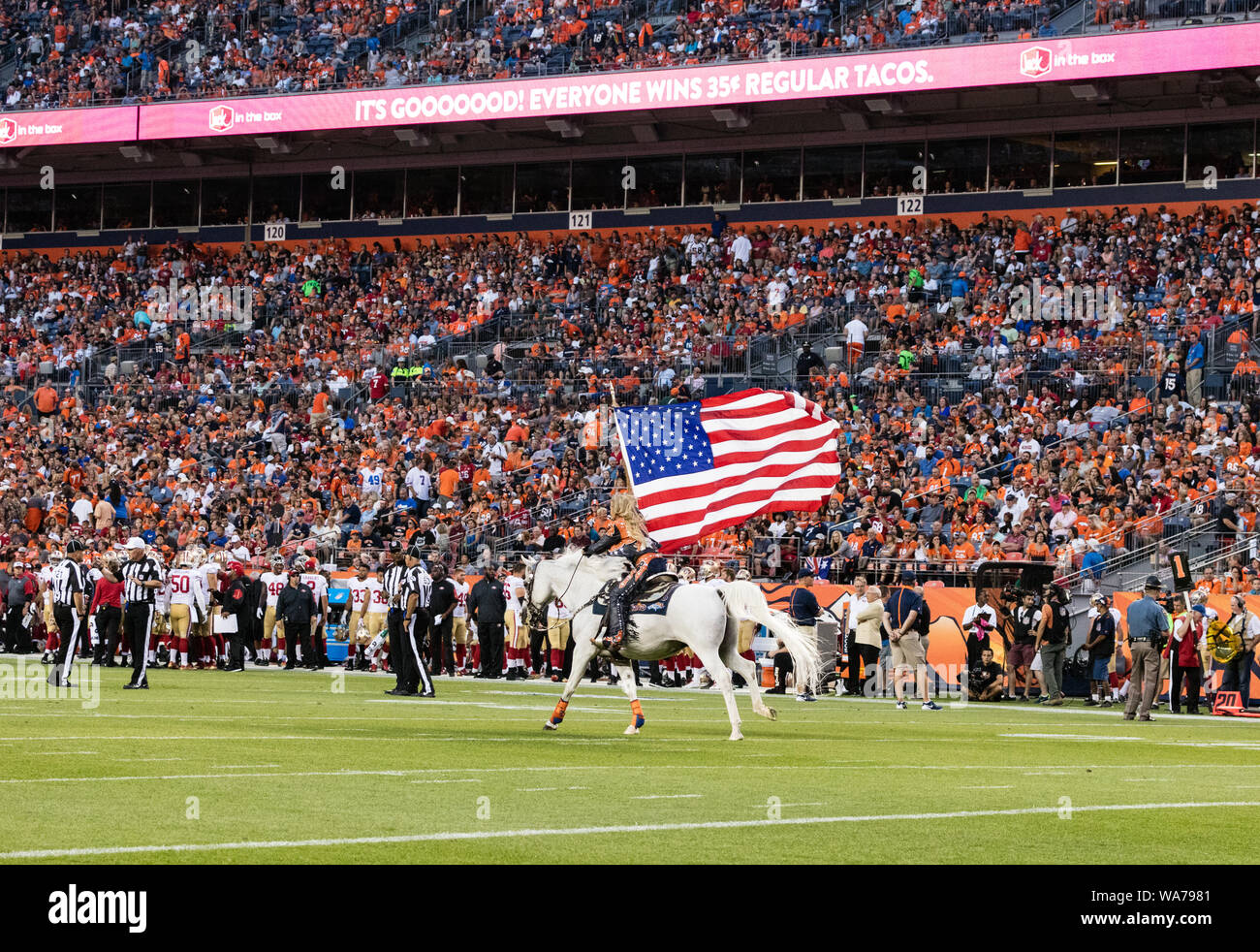 Eine Frau reitet ein weißer Hengst über das Feld ein Denver Broncos Touchdown, während das Team der nationalen Fußball-Liga Spiel gegen den Besuch in San Francisco 49ers an der Sports Authority Feld bei Mile High Stadium, Denver, Colorado, zu feiern. Stockfoto
